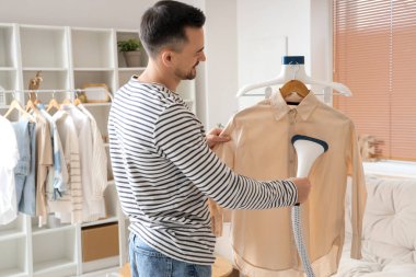 Yakışıklı, buharlı giysiler ve modern bir buharlı ev.