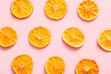 Dried orange slices on pink background