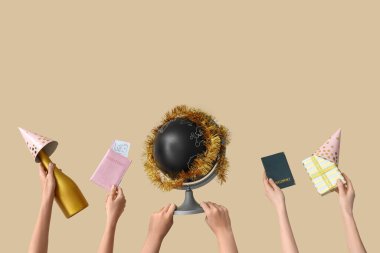 Female hands holding passports with globe and champagne on light background. New year vacation concept