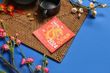 Greeting card with teapot, cup and decor on blue background. Chinese New Year celebration
