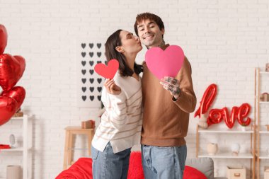 Young couple with paper hearts having date at home. Valentine's day celebration