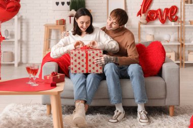 Genç adam sevgilisini sevgililer gününde evde karşılıyor.