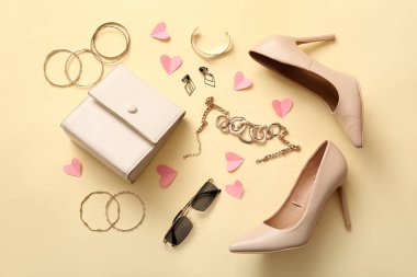 Composition with stylish high-heeled shoes, female accessories and paper hearts on color background. Valentine's Day celebration