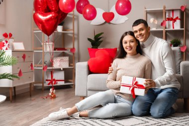 Evde Sevgililer Günü hediyesi olan genç bir çift.