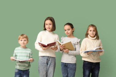 Little children reading books on green background