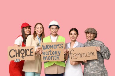 Women of different professions holding cardboard pieces with different text on pink background. Women history month