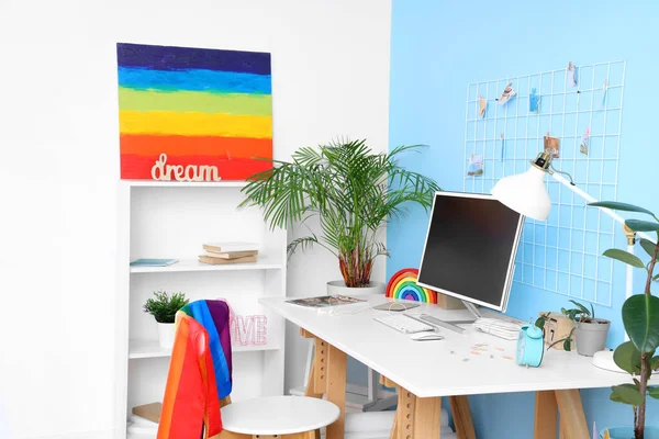 Interior of office with workplace, LGBT flag and painting