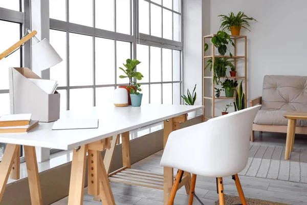 Modern workplace with houseplants in living room interior