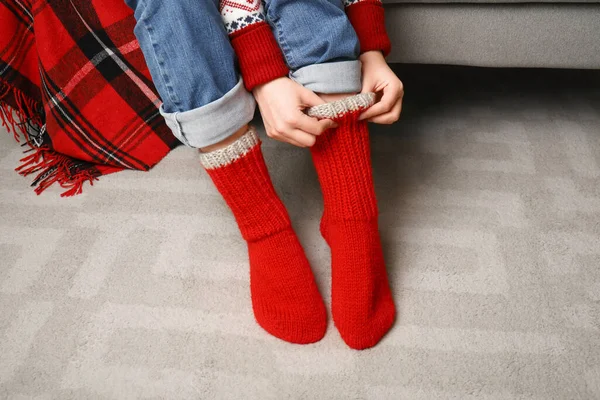 Woman in red knitted socks at home