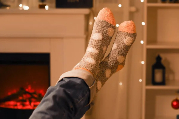 Woman in warm socks at home on Christmas eve