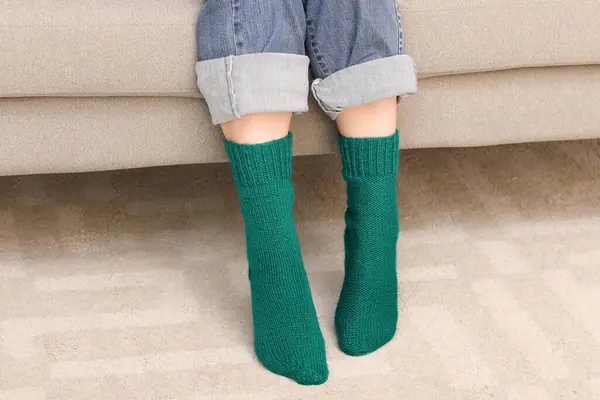 Woman in green knitted socks at home