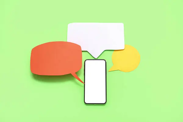 Mobile phone with blank screen and empty speech bubbles on green background