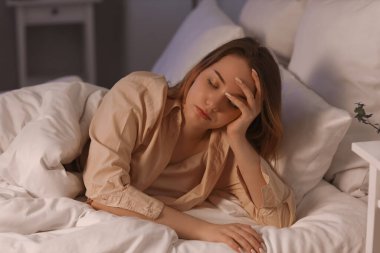 Young woman lying in bed at night
