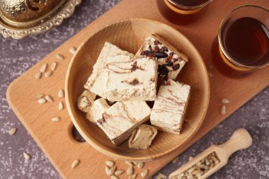 Lezzetli mermer helva parçaları ve arkaplanda Türk çayı olan bardaklar.