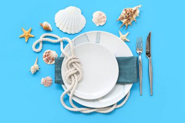 Mavi arka planda deniz dekoruyla servis edilen güzel bir masa.