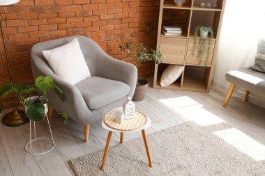 Oturma odasının içinde şık gri koltuk ve kahve masası.