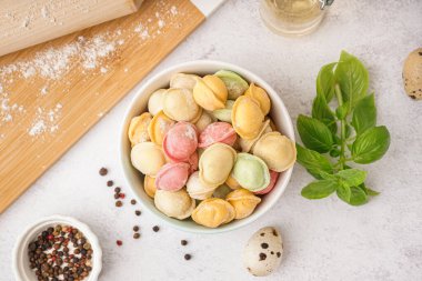 Beyaz arka planda biberli ve fesleğenli renkli çiğ hamur köfteleri.