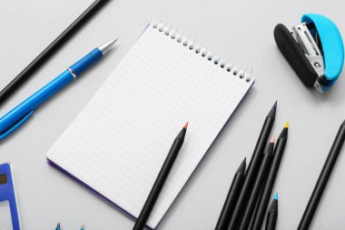 Gri arkaplanda kırtasiye malzemesi olan bir sürü renkli kalem