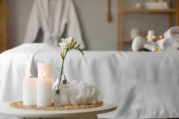 Spa composition with burning candles on table in salon, closeup