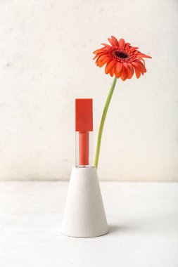 Dekoratif alçı kürsüsü ve beyaz masa üzerinde gerbera çiçeği.