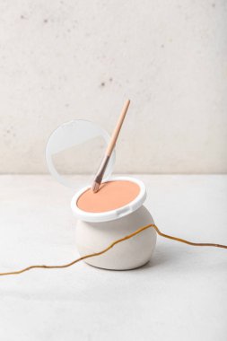 Beyaz masa üzerinde toz, fırça ve ağaç dallarıyla dekoratif sıva podyumu