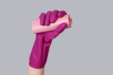 Gri arka planda çöp torbaları olan kauçuk eldiven verin.