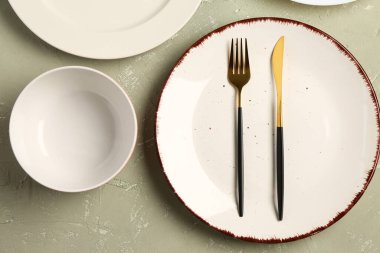 Gri grunge masa üzerinde temiz tabak, kase ve çatal bıçak seti.