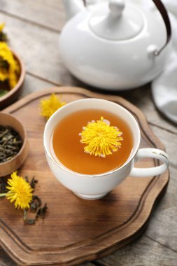 Sağlıklı karahindiba çayı ve ahşap zemin üzerinde çaydanlık.