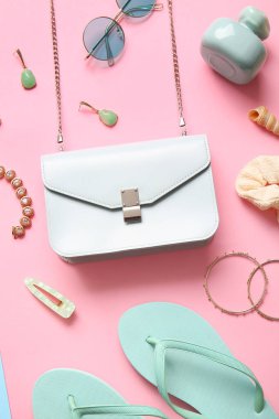 Pembe arka planda şık çanta ve farklı aksesuarlar.