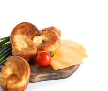 Beyaz arka planda lezzetli Yorkshire pudingi ve peyniri olan ahşap tahta tahta.