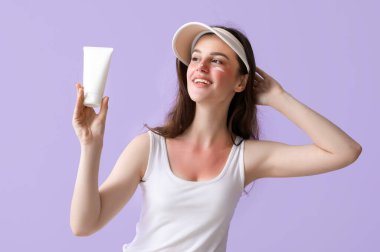 Güneşte yanmış yüzü ve kremi olan alerjisi olan genç bir kadın.