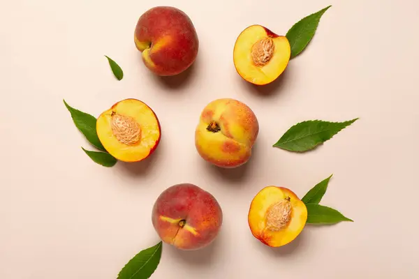 Sweet peaches and leaves on beige background