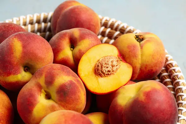 Wicker bowl with sweet peaches, closeup
