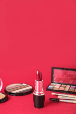 Kırmızı arkaplanda ruj izi olan dekoratif kozmetik seti