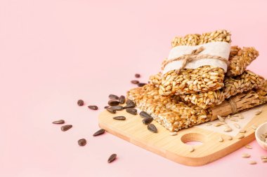 Lezzetli kozinakili tahta ve pembe arka planda ayçiçeği tohumları