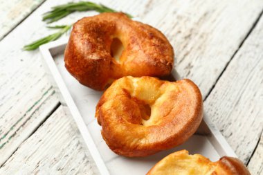 Hafif ahşap arka planda lezzetli Yorkshire pudingi tabağı.