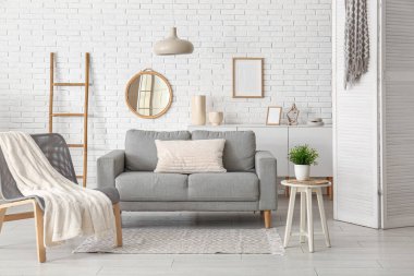 Modern oturma odası. Gri kanepe, koltuk ve katlanmış ekran.