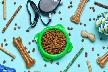 Renk arka planında farklı köpek maması ve hayvan bakım aksesuarları olan kompozisyon