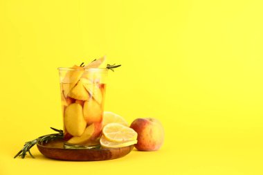 Taze şeftalili limonata ve biberiyeli ahşap tabak.