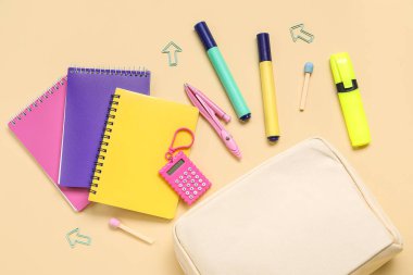 Bej arka planda farklı okul kırtasiyesine sahip kalem kutusu