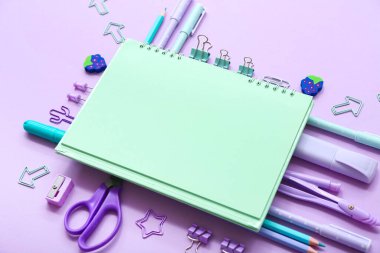 Leylak arkaplan üzerine farklı kırtasiye malzemesi içeren defter