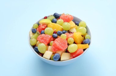 Mavi arka planda taze meyve salatası.