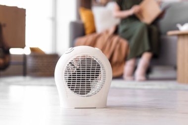 Electric fan heater on floor in living room