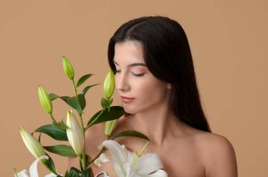 Beyaz zambak çiçekleriyle güzel genç bir kadın, yakın plan.