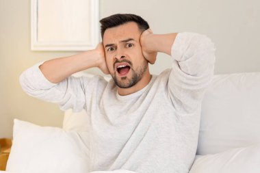 Kızgın genç adam yatak odasında gürültücü komşulardan muzdarip.