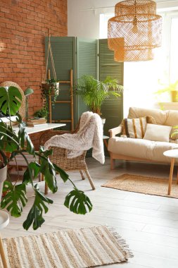 Çalışma odası, yeşil bitkiler ve kanepe.