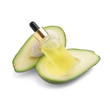 Bir şişe temel yağ ve beyaz arka planda taze avokado.