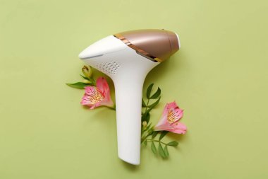 Modern fotoepilatör ve yeşil arka planda güzel orkide çiçekleri olan kompozisyon