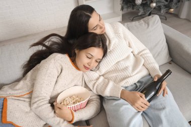 Yeni yıl partisinden sonra kanepede uyuyan sarhoş genç kadınlar.