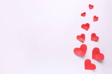 Işık arkaplanda kırmızı kağıt kalplerle kompozisyon. Sevgililer Günü kutlaması